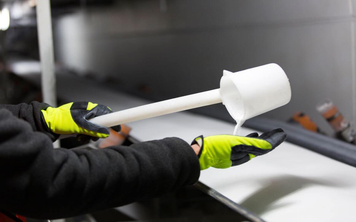 White granules powder being poured into gloved hand